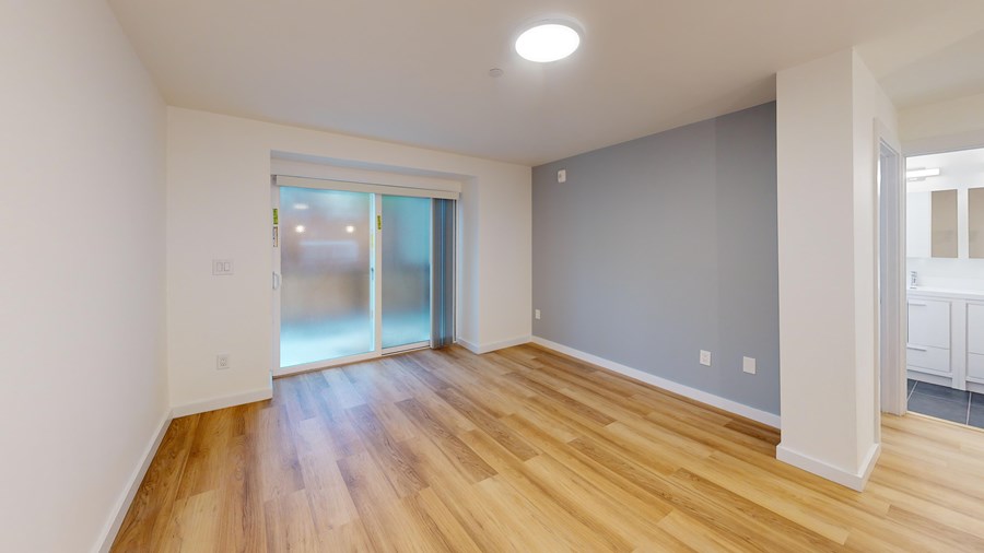A room with wooden floors and a sliding glass door.